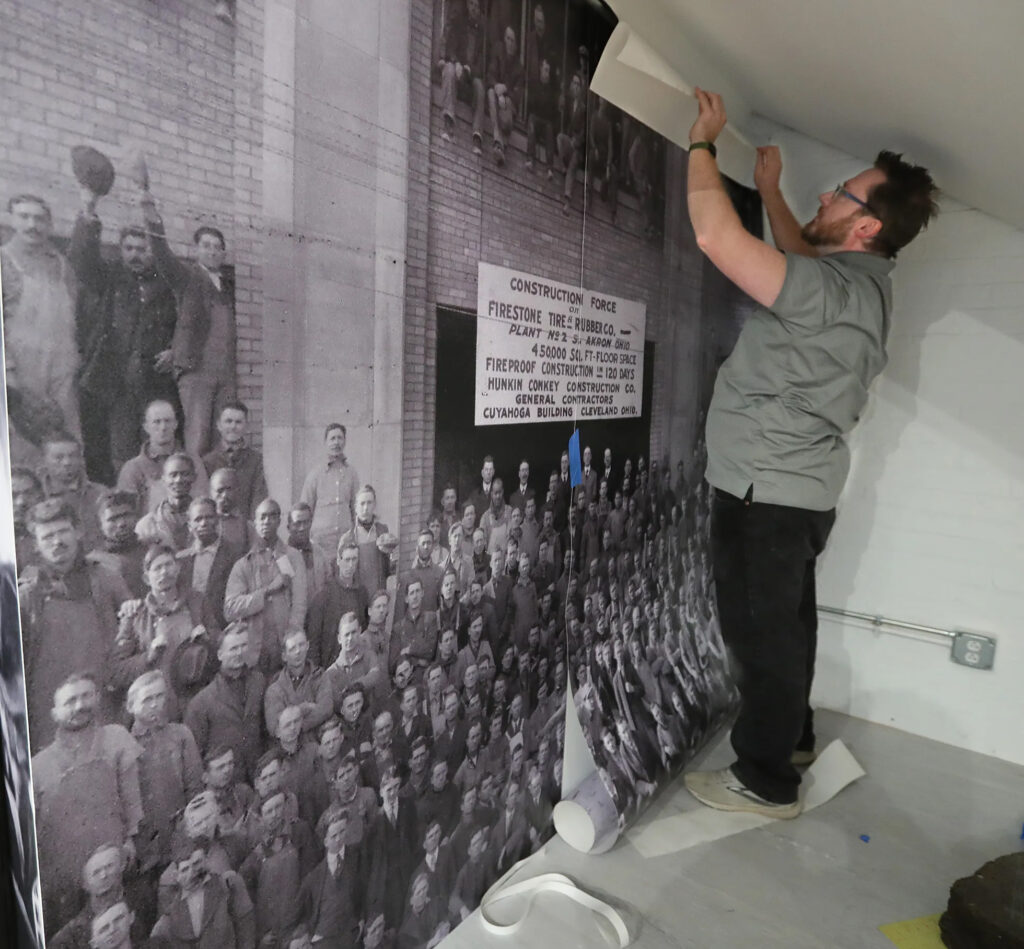 Work continues at the Akron History Center on South Main Street. A giant reproduction of the cover of Devo’s 1978 debut album is being installed as a salute to the Akron Sound. In the background is a wing-footed statue of Mercury. PHIL MASTURZO/AKRON BEACON JOURNAL