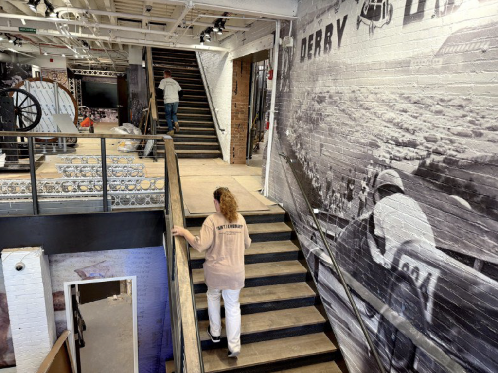 Leianne Neff Heppner, president and CEO of the Summit County Historical Society, climbs the stairs between floors at the Akron History Center in downtown Akron, Oct. 24, 2024. (Kevin Dilley / Signal Akron)