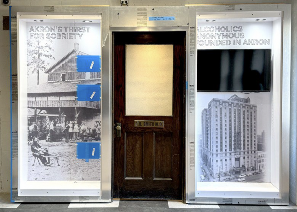 An exhibit still under construction at the Akron History Center in downtown Akron, Oct. 24, 2024, features the original office door for Dr. Robert H. Smith, known as Dr. Bob, the founder of Alcoholics Anonymous. (Kevin Dilley / Signal Akron)